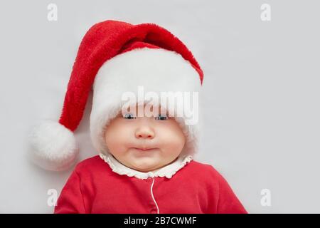 I bambini vestiti da Babbo Natale in piedi su sfondo scuro con pattern di Natale. Nuovo anno. Foto Stock