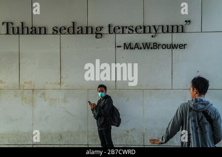 Bandung, Indonesia. 15 Mar 2020. Un uomo guarda mentre indossa una maschera protettiva come misura preventiva contro la diffusione di Coronavirus vicino alla piazza Alun-alun a Bandung.Il governo della città di Bandung ha cominciato a chiudere tutti gli spazi pubblici per due settimane, Uno dei quali è Piazza Alun-Alun come uno sforzo per prevenire la diffusione di Coronavirus. Credit: Sopa Images Limited/Alamy Live News Foto Stock