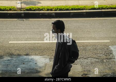 Bandung, Indonesia. 15 Mar 2020. Un uomo cammina mentre indossa una maschera protettiva come misura preventiva contro la diffusione del Coronavirus vicino alla piazza Alun-alun a Bandung. Il governo della città di Bandung ha iniziato a chiudere tutti gli spazi pubblici per due settimane, uno dei quali è Piazza Alun-Alun come uno sforzo per prevenire la diffusione del Coronavirus. Credit: Sopa Images Limited/Alamy Live News Foto Stock