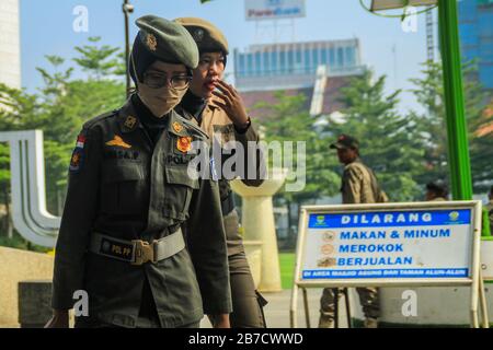 Bandung, Indonesia. 15 Mar 2020. Un ufficiale di guardia indossa una maschera protettiva come misura preventiva contro la diffusione del Coronavirus nella piazza Alun-alun a Bandung. Il governo della città di Bandung ha iniziato a chiudere tutti gli spazi pubblici per due settimane, uno dei quali è Piazza Alun-Alun come uno sforzo per prevenire la diffusione del Coronavirus. Credit: Sopa Images Limited/Alamy Live News Foto Stock