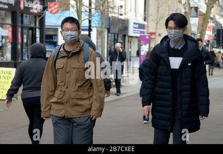 Due giovani cinesi che indossano maschere facciali durante lo scoppio del virus Corona. A Nottingham Foto Stock