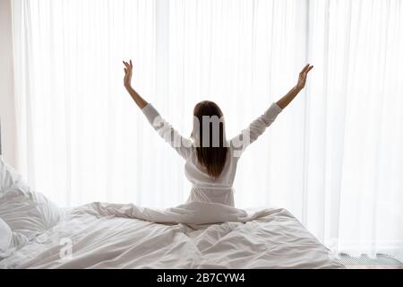 Retro vista giovane brunetta donna stretching muscoli. Foto Stock