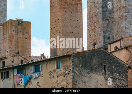 Torri medievali ed edifici residenziali di San Gimignano visti da Via Folgore da S. Giminiano vicino alla Galleria d'Arte moderna Raffaele De Grada. Foto Stock