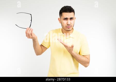 uomo occhi irritati da indossare occhiali su uno sfondo bianco Foto Stock