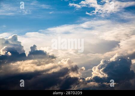 Raggi di sole tra le nuvole nel cielo blu Foto Stock