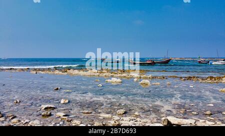 NGWE SAUNG/MYANMAR - 14 MARZO 2020 : i pescatori birmani portano pesce catturato in cesti sulla spiaggia Ngwe Saung Myanmar Foto Stock