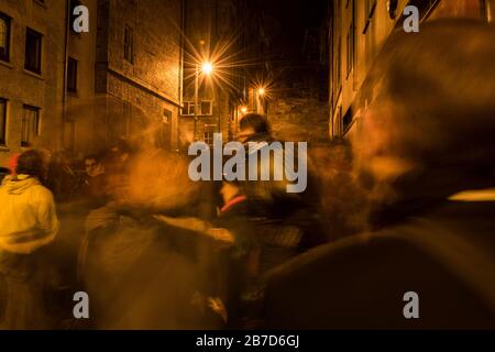 Un'astratta scena di strada spettrale della processione di Hogmanay a Edimburgo, Scozia, di persone che camminano e si muovono. Foto Stock