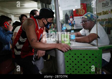 Manila, Filippine. 15 Mar 2020. La gente si affonda a un terminal degli autobus a Cubao, Quezon City per lasciare la capitale il Venerdì, 13 marzo 2020 a seguito di un annuncio del Presidente Rodrigo Duterte il giovedì sera di un imminente blocco di 30 giorni della Metro Manila, a partire dal 15 marzo fino ad aprile 14, per contenere la diffusione del coronavirus (COVID19) nel paese. (Foto Larry Monserate Piojo/Sipa Usa) Credit: Sipa Usa/Alamy Live News Foto Stock