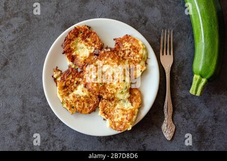 Frittelle di zucchine croccanti con uova, farina e cipolla. Foto Stock