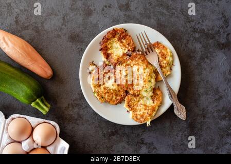 Frittelle di zucchine croccanti con uova, farina e cipolla. Foto Stock