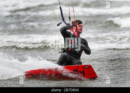 Troon, Regno Unito. 15 Mar 2020. Non tutti gli sport sono limitati dalla paura di diffondere Covid-19 e gli appassionati di sport acquatici approfittano dei forti venti e delle alte onde sul Firth of Clyde al largo della costa dell'Ayrshire. Credit: Findlay/Alamy Live News Foto Stock