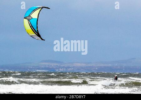 Troon, Regno Unito. 15 Mar 2020. Non tutti gli sport sono limitati dalla paura di diffondere Covid-19 e gli appassionati di sport acquatici approfittano dei forti venti e delle alte onde sul Firth of Clyde al largo della costa dell'Ayrshire. Credit: Findlay/Alamy Live News Foto Stock