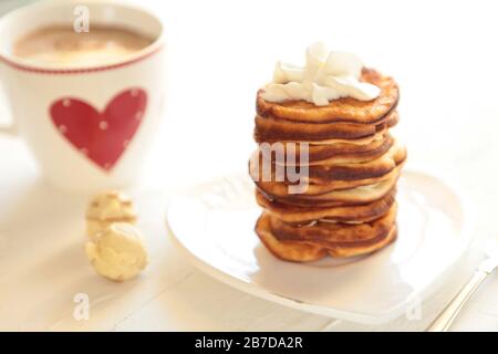 Frittelle fatte in casa con colazione tazza di caffè. Una sana prima colazione al mattino con caramelle. Foto Stock