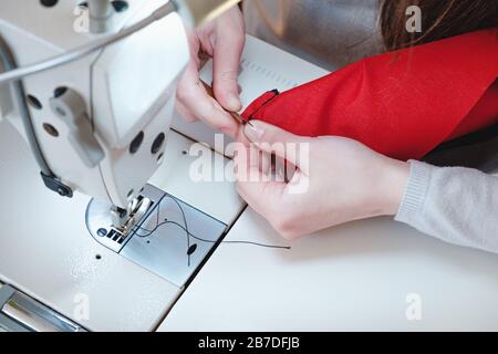 Le mani di marinaio sul lavoro. Needlewoman alla macchina da cucire overlock facendo lavoro professionale, concetto di lavoro Foto Stock