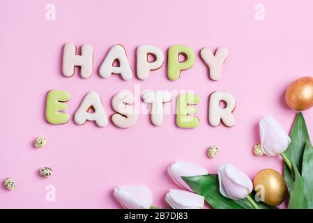 Congratulazioni buona carta di Pasqua da pollo dipinto a mano e uova di quaglia, fiori tulipani e testo di biscotti fatti in casa a base di lettere su un bac rosa Foto Stock