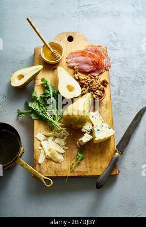 Un set di antipasti con formaggio, frutta, noci e miele Foto Stock