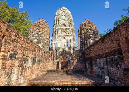 Rovine dell'antico tempio buddista Wat si Sawai in una giornata di sole. Parco storico di Sukhothai, Thailandia Foto Stock