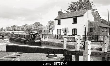 Narrowboat nella chiusa accanto al cottage vicino a Newton Harcourt sul Grand Union Canal Leicester Arm, Inghilterra, Regno Unito, Gran Bretagna, Leicestershire Foto Stock