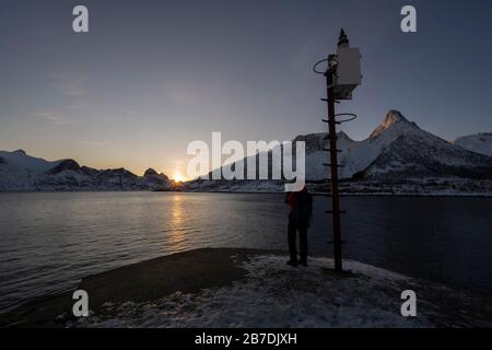 Fotografo maschile che cattura il paesaggio invernale a Senja e Norlandet catena montuosa, Norvegia. Foto Stock