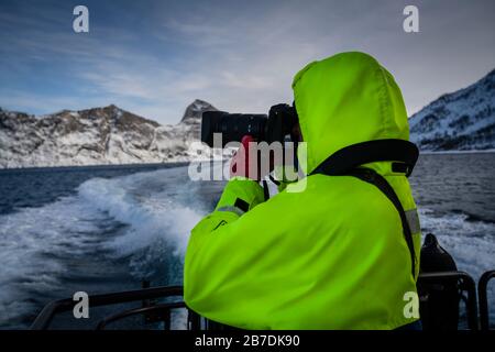 Fotografo maschile che cattura il paesaggio invernale a Senja e Norlandet catena montuosa, Norvegia. Foto Stock
