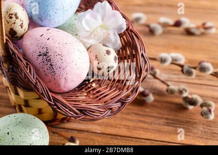 Congratulazioni carta di Pasqua dal cestino con pollo dipinto a mano e uova di quaglia su uno sfondo di legno. Foto Stock