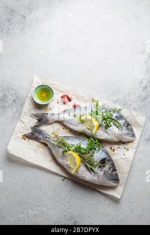 Orata di mare cruda o dorada con erbe e limone Foto Stock