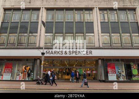 Punto vendita Marks & Spencer su Southend High Street con cartelli di vendita e negozi di passaggio durante una giornata intensa. Foto Stock