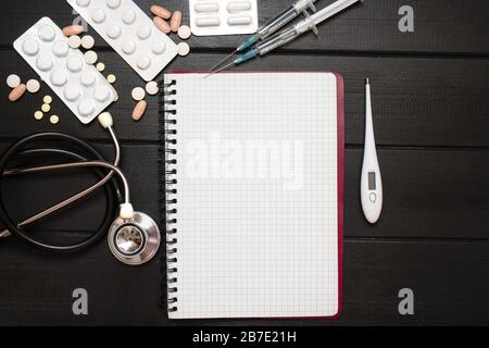 Prescrizione di farmaci con pillole e stetoscopio si trova su tavola di legno. Compressa o farmaco. Medicina e concetto sano. Copiare lo spazio per il testo. Primo piano. Foto Stock