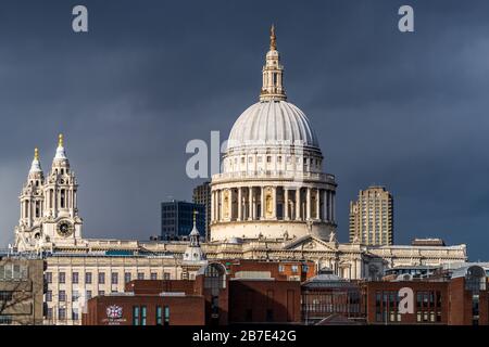 St Paul's Cathedral Londra illuminata dal sole della sera contro le nuvole scure. Consacrato 1697, Architetto Sir Christopher Wren Foto Stock