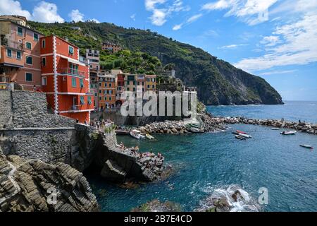 RIOMAGGIORE, ITALIA - 15 agosto 2019: Vista su Riomaggiore e sul mare e le scogliere delle cinque Terre in una giornata di sole Foto Stock