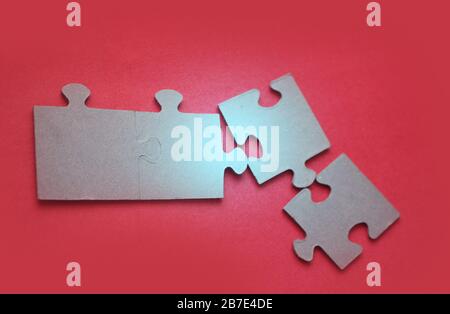 Luce brillante su puzzle su sfondo rosso, primo piano Foto Stock