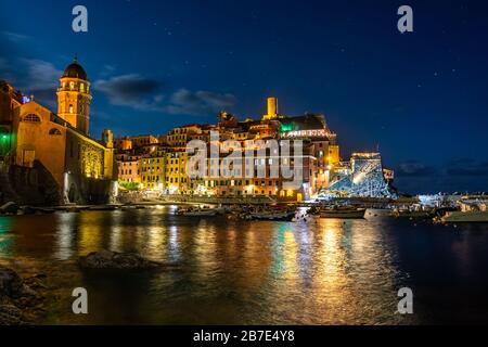 Vernazza illuminata e l'oceano di notte alle cinque Terre Foto Stock