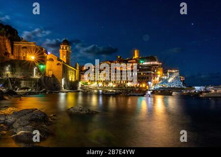 Vernazza illuminata e l'oceano di notte alle cinque Terre Foto Stock