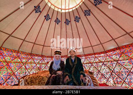 Coppia di Kyrgyz in costumi nazionali, in una tenda nomade conosciuta come yurt, vicino alla città di Bishkek, Kirghizistan Foto Stock