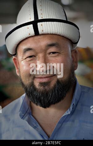 Uomo kirghiso con cappello locale a Bishkek, Kirghizistan Foto Stock