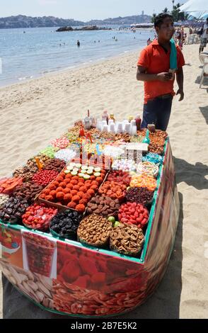 Caramelle con peperoncino venditore sulla spiaggia, Acapulco, Messico Foto Stock