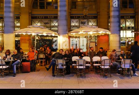 Parigini e turisti siedono sulla terrazza del caffè le Nemours. Questo famoso caffè si trova vicino al Palais Royal e alla Comedie Francaise. Foto Stock