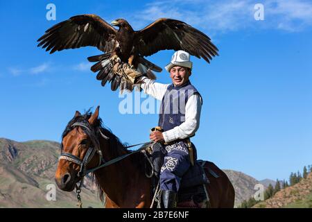 Allenatore di aquila d'oro che tiene la sua aquila Issyk Kul Lago, Kirghizistan Foto Stock