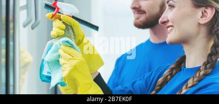 Team di pulitori commerciali che lavorano in un ufficio Foto Stock