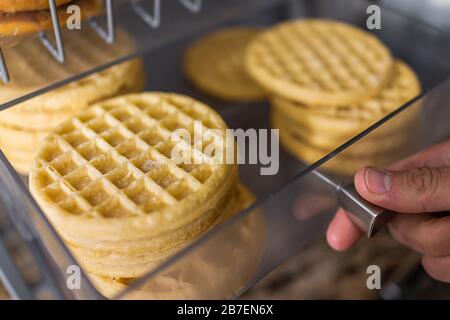 Macrosello di waffle ad apertura a mano sul vassoio da forno a buffet per colazione continentale al mattino nel motel o nell'ufficio dell'hotel Foto Stock