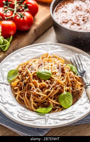 Pasta italiana spaghetti bolognese serviti su piatto bianco con parmigiano e basilico Foto Stock