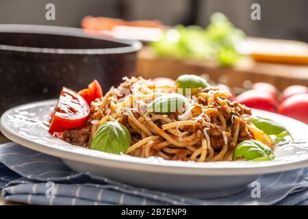 Pasta italiana spaghetti bolognese serviti su piatto bianco con parmigiano e basilico Foto Stock