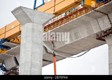 Nuova costruzione del ponte sul porto, pensata per i lavoratori con sollevatore esteso, per la pulizia dei giunti in cemento sotto il ponte. Foto Stock