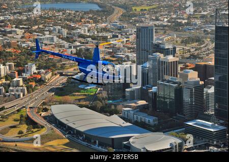 Un'immagine Air to Air di un elicottero Robinson R44 su un volo panoramico sulla città di Perth, Australia Occidentale. Foto Stock