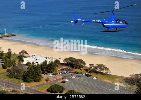 Un'immagine Air to Air di un elicottero Robinson R44 su un volo panoramico su City Beach, Perth, Australia Occidentale. Foto Stock