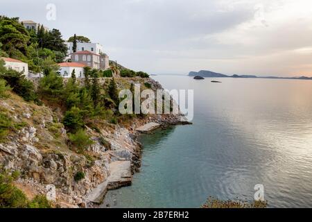 Spiagge, case di lusso e mare calmo lungo la costa del mare di Agea dell'isola greca, Hydra, Grecia Foto Stock