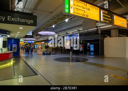 Molto tranquillo aeroporto Schiphol causato dalla chiusura di negozi, caffè e ristoranti da parte del governo a causa del virus corona in Olanda Foto Stock