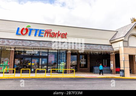 Herndon, Stati Uniti d'America - 12 novembre 2019: Strada esterna nel centro commerciale strip e donna a piedi al mercato asiatico Lotte prodotti in Virginia Fairfax County Foto Stock