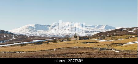 Primavera nelle Highlands scozzesi presso il Cottage di Blairglass abbandonato, con Lochnagar sul Royal Deeside ancora coperto di neve Foto Stock