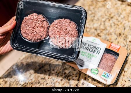 Herndon, Stati Uniti d'America - 3 febbraio 2020: Uomo mano maschile tenuta crudo crudo uncooked Oltre Burger pacchetto di piante a base di polpette con hamburger sopra cucina countertop Foto Stock